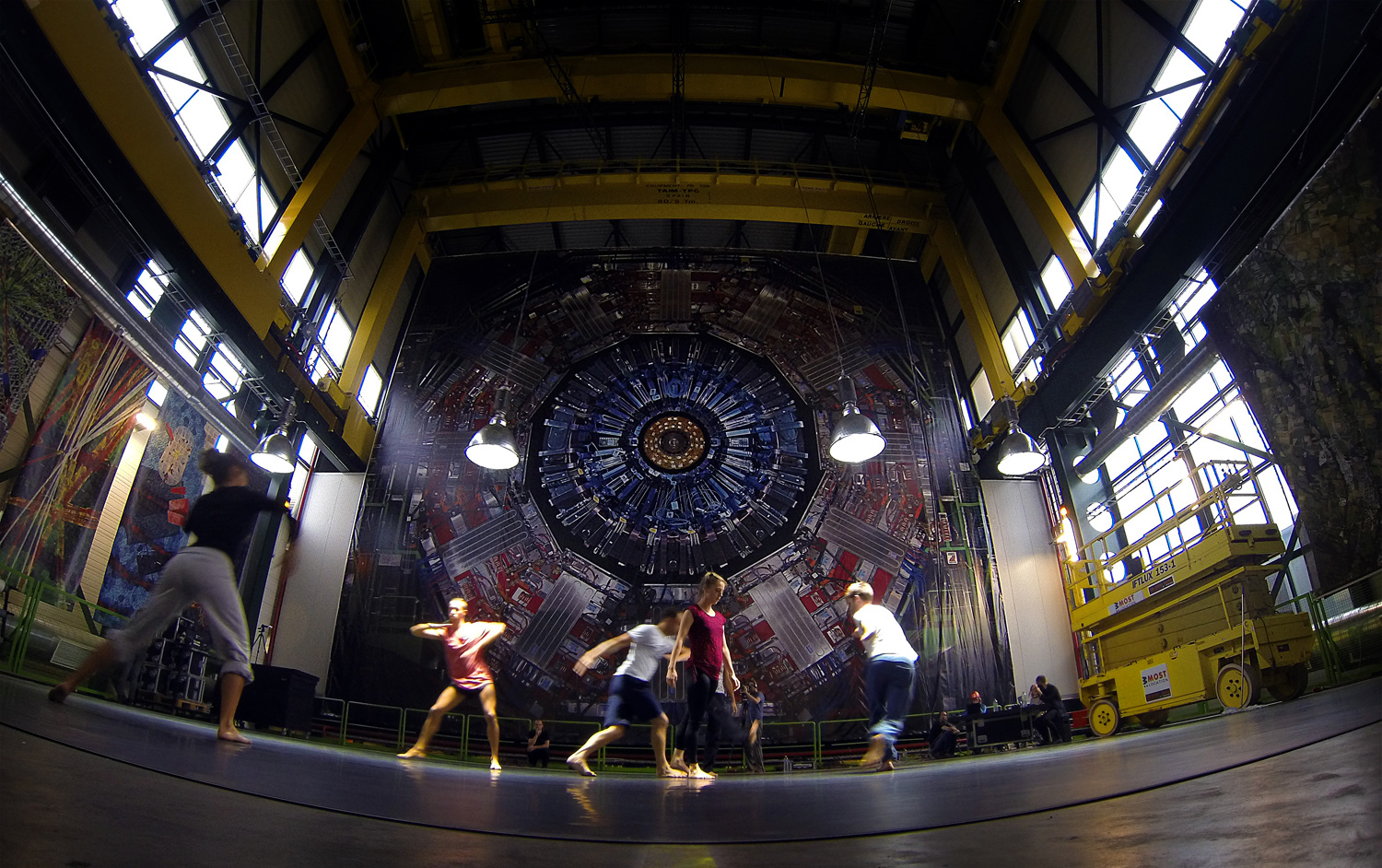 Dancers rehearse at Point 5 on the LHC for the contemporary dance piece QUANTUM, beneath a lighting installation by Julius von Bismarck and a poster of the CMS detector (Image: Michael Hoch/CERN)