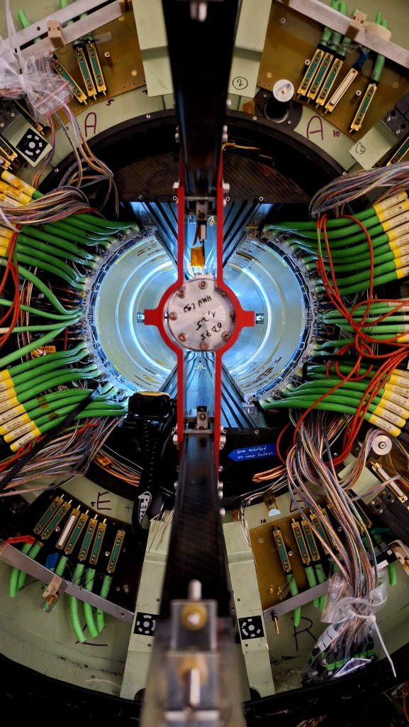Looking along the beam axis into the CMS tracker region. Dense bundles of power, cooling and readout services surround the central opening, illustrating the intricate work required to disconnect and remove legacy detector components during LS3. 